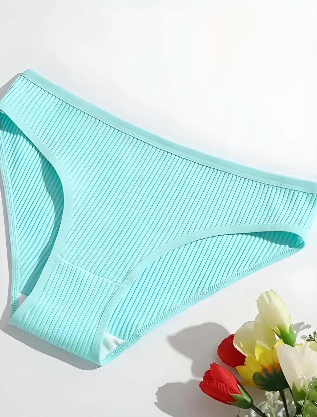 Light blue bikini bottom on a white background with flowers at the bottom right corner.